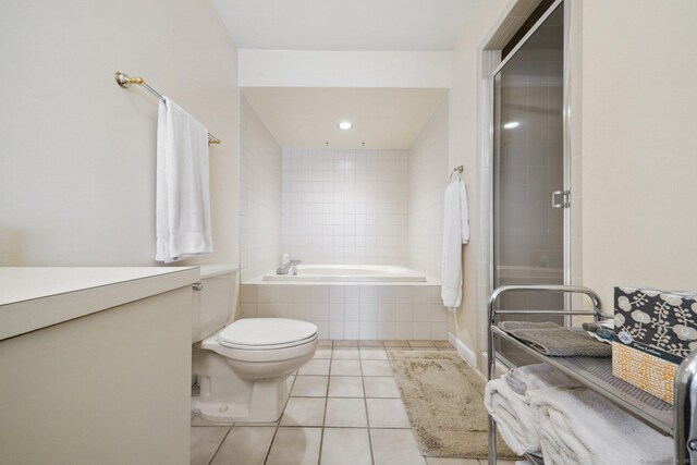 bathroom with tile patterned floors, a garden tub, a shower stall, and toilet