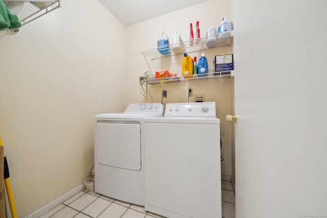 washroom with washing machine and dryer, light tile patterned floors, and baseboards