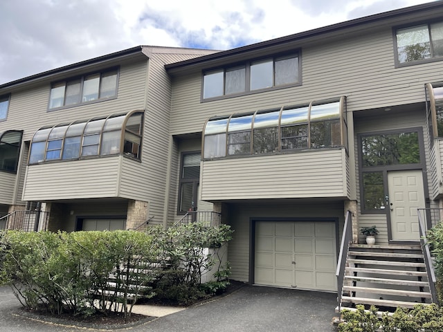 view of front of home with a garage and asphalt driveway