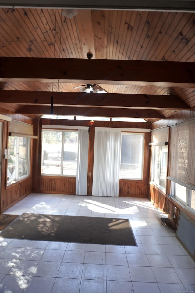 unfurnished room featuring light tile patterned floors, beamed ceiling, and wood walls