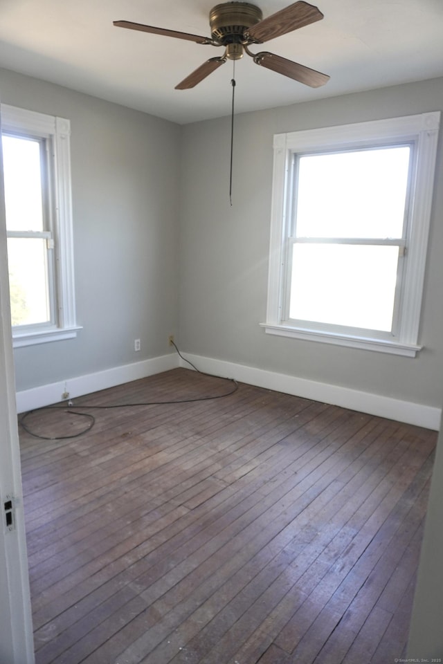 empty room with ceiling fan, baseboards, and hardwood / wood-style flooring