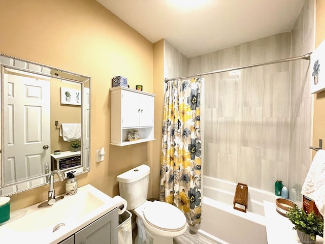 bathroom with vanity, shower / bath combination with curtain, and toilet