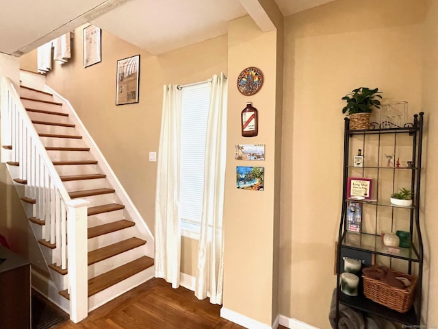 stairway featuring baseboards and wood finished floors