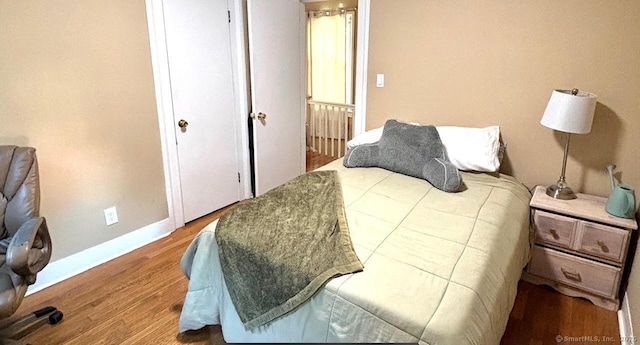 bedroom featuring baseboards and wood finished floors