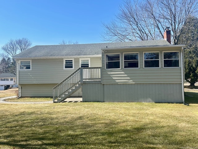 view of front of home featuring a shingled roof, a front yard, and a chimney