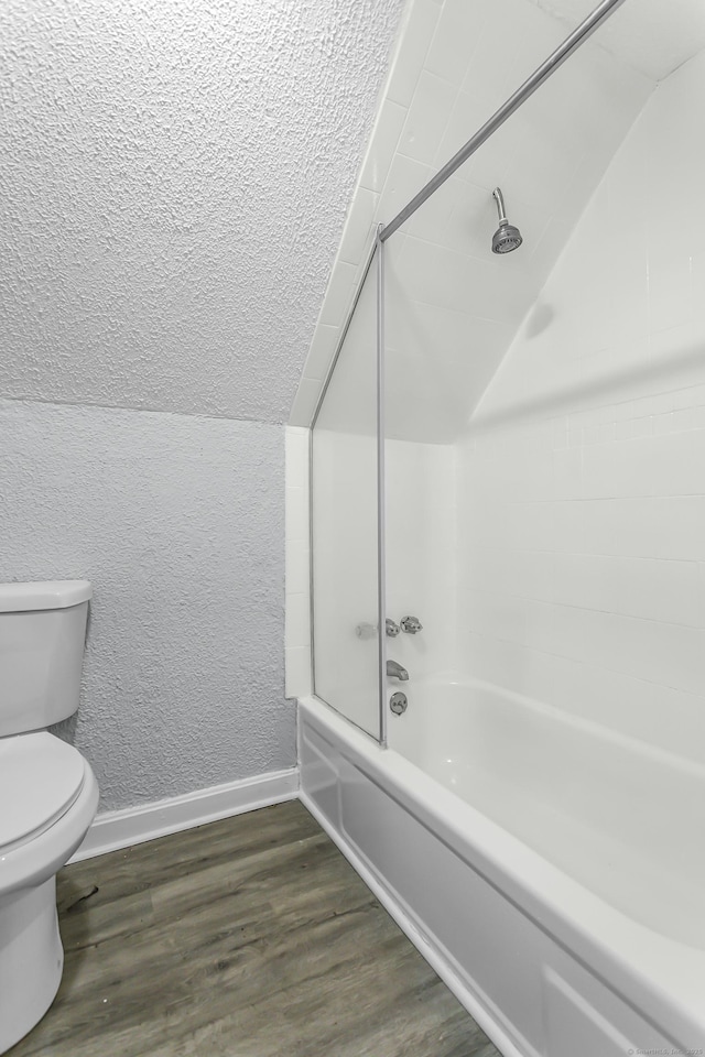 full bathroom featuring baseboards, lofted ceiling, toilet, and wood finished floors