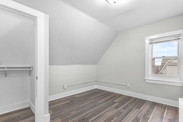 bonus room featuring lofted ceiling, baseboards, and dark wood-style flooring