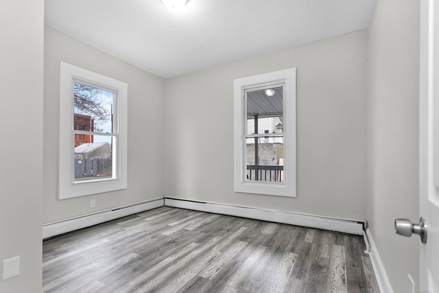 unfurnished room featuring wood finished floors, a healthy amount of sunlight, and baseboards