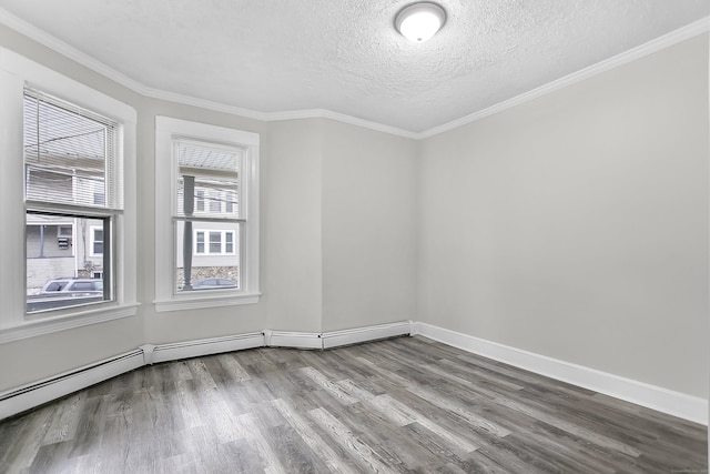 empty room featuring wood finished floors, baseboards, a textured ceiling, a baseboard heating unit, and crown molding