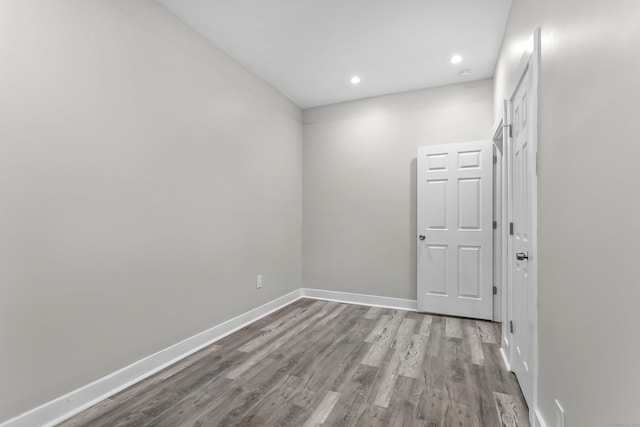 empty room with recessed lighting, baseboards, and wood finished floors