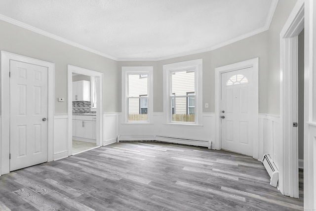 foyer with a wainscoted wall, wood finished floors, a baseboard heating unit, and a baseboard radiator