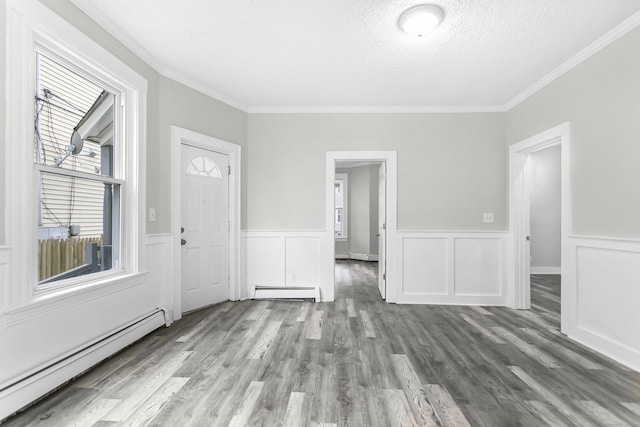 interior space featuring wood finished floors, a textured ceiling, crown molding, and a baseboard radiator