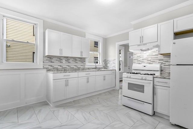 kitchen with under cabinet range hood, a sink, white cabinetry, white appliances, and crown molding