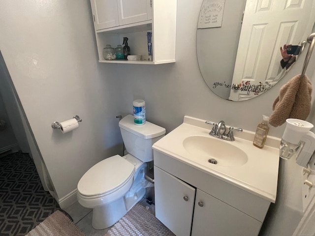 bathroom featuring vanity, toilet, and tile patterned flooring