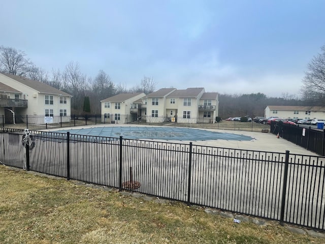 pool with a patio area, a residential view, and fence