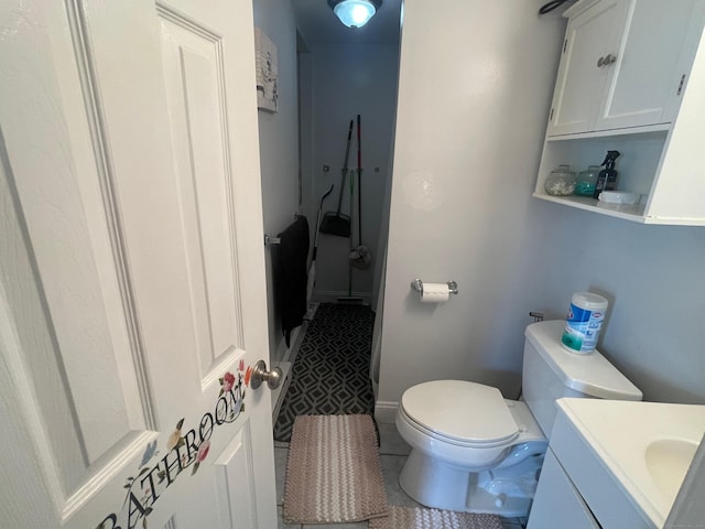 bathroom featuring vanity, tile patterned floors, and toilet