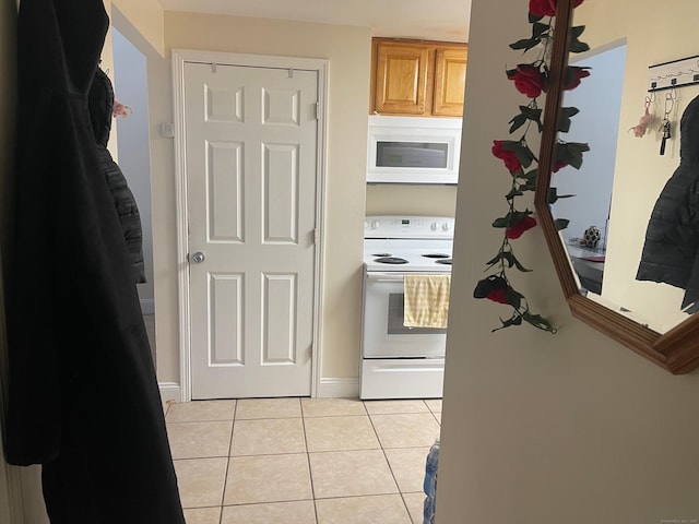kitchen featuring white appliances and light tile patterned flooring