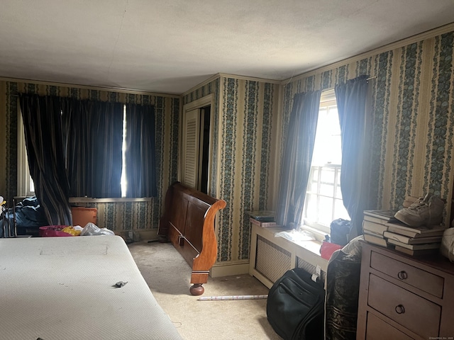 bedroom with ornamental molding, wallpapered walls, and carpet floors