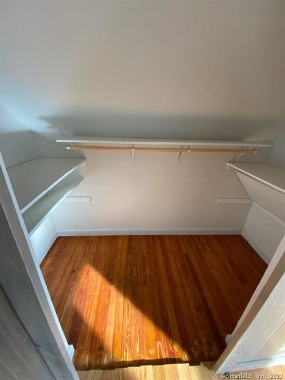 walk in closet with wood finished floors