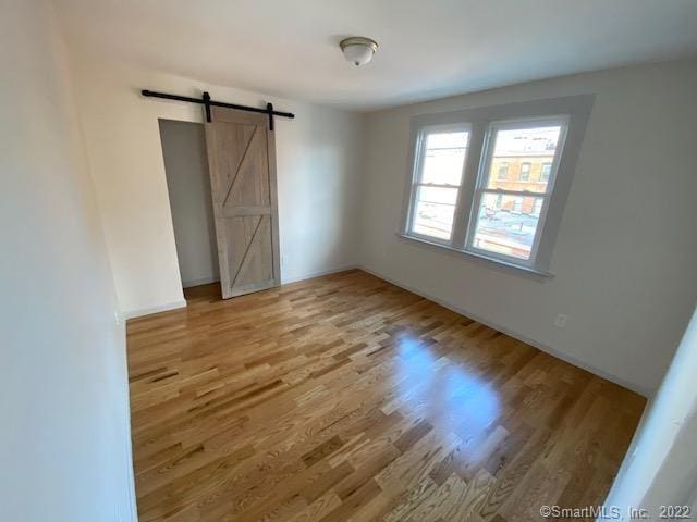 spare room featuring a barn door and wood finished floors