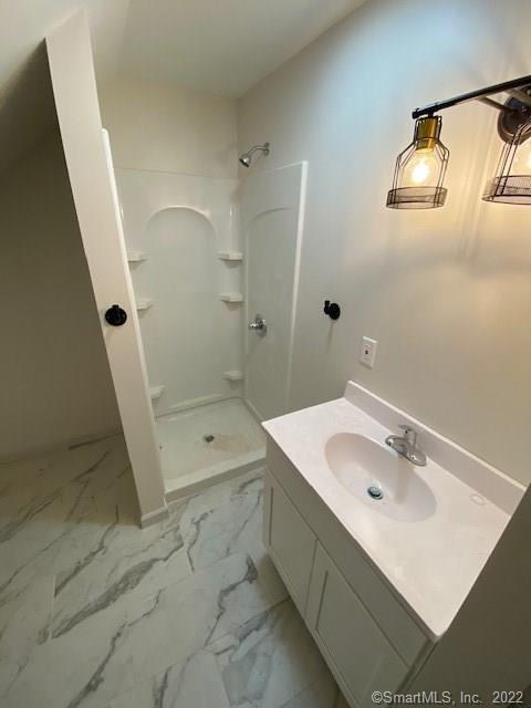 bathroom with vanity, marble finish floor, and a shower stall