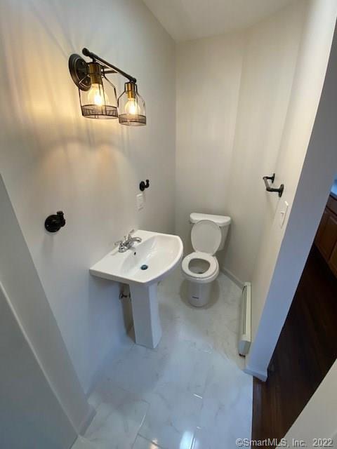 bathroom with a baseboard heating unit and toilet