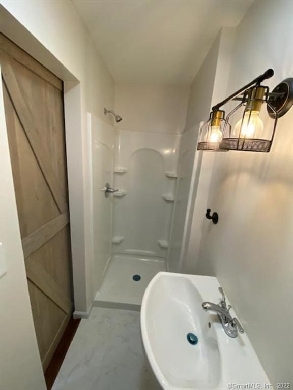 bathroom featuring a shower stall and a sink