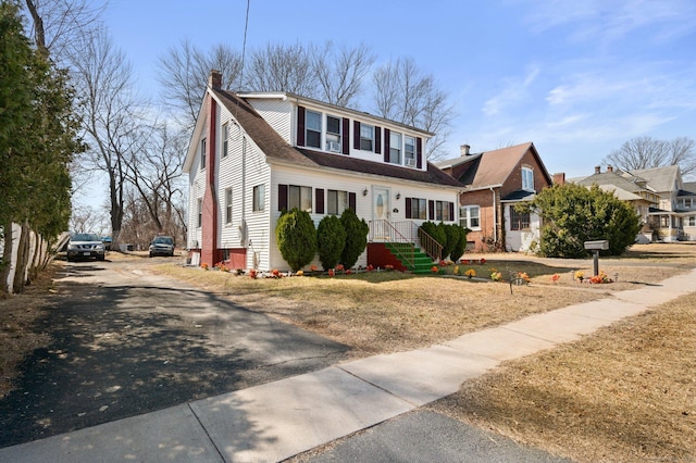 view of front of house featuring driveway and a chimney