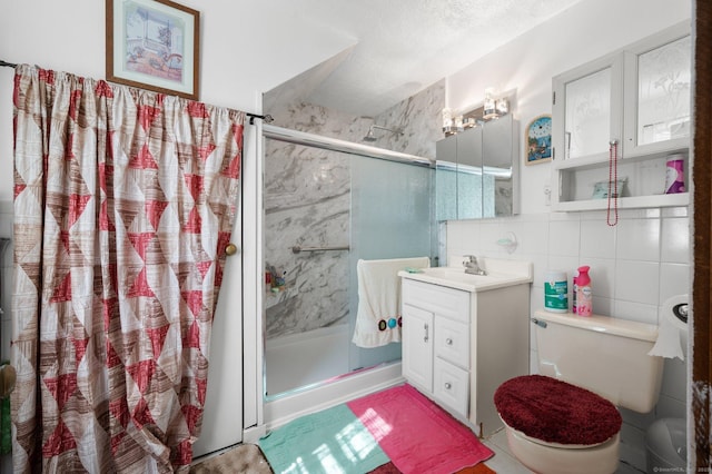 bathroom with a shower stall, toilet, vanity, decorative backsplash, and tile walls