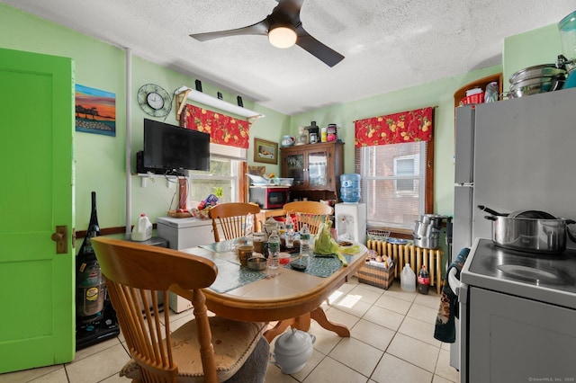 dining area with light tile patterned floors, a textured ceiling, and a ceiling fan