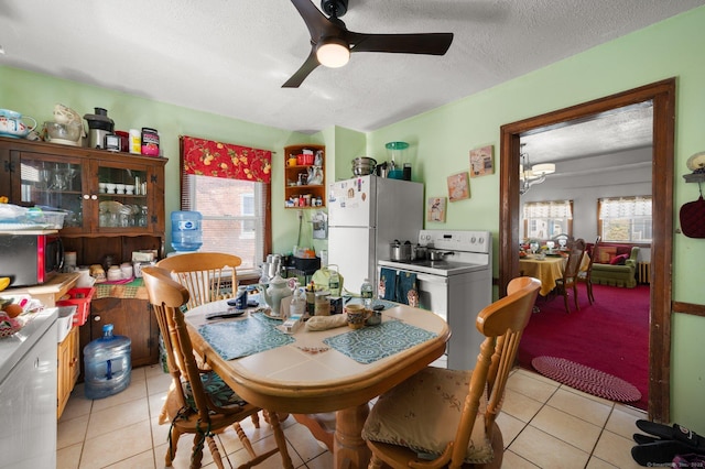 dining room featuring a wealth of natural light, ceiling fan, and light tile patterned flooring