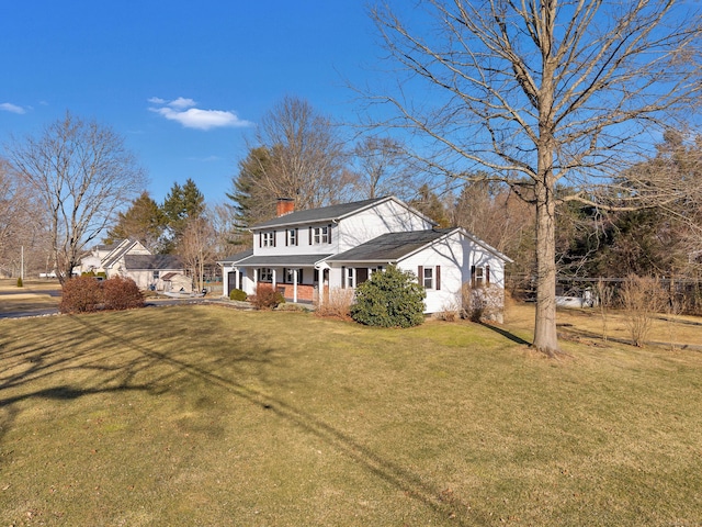 view of front of home with a porch, a chimney, and a front lawn