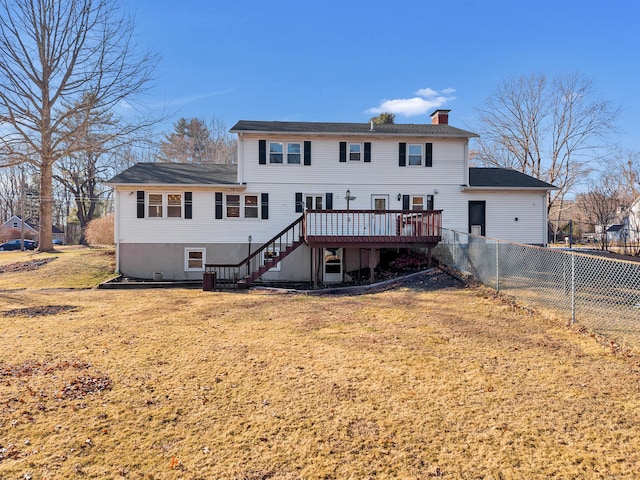 rear view of property featuring fence, stairs, a lawn, a chimney, and a deck