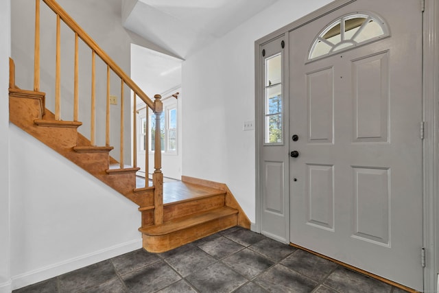 entrance foyer featuring stairway and baseboards