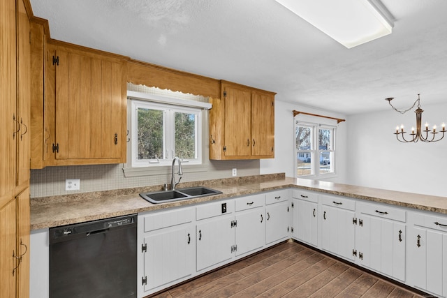 kitchen featuring dark wood finished floors, dishwasher, light countertops, white cabinets, and a sink