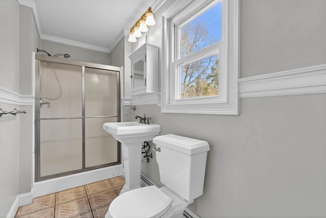 bathroom featuring a shower stall, toilet, and crown molding