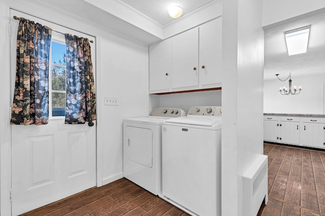 clothes washing area featuring radiator, cabinet space, separate washer and dryer, and dark wood-style flooring