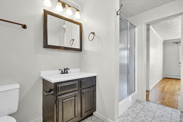 full bath featuring a baseboard heating unit, toilet, a stall shower, and vanity