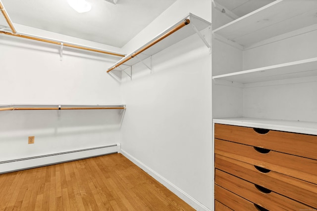 spacious closet featuring a baseboard radiator and light wood finished floors