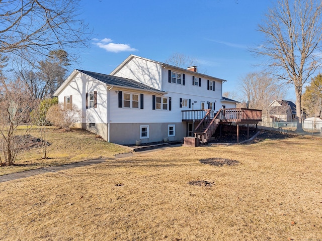 back of property with fence, a wooden deck, stairs, a chimney, and a yard