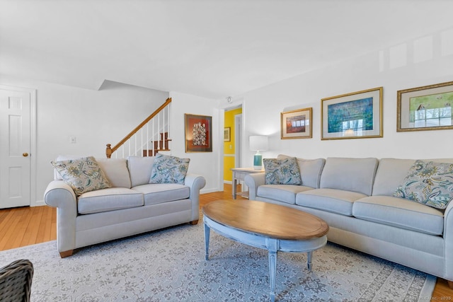 living room featuring stairway, wood finished floors, and baseboards