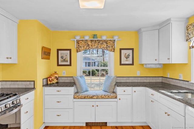 kitchen featuring white cabinetry, gas range, dishwasher, and dark stone counters