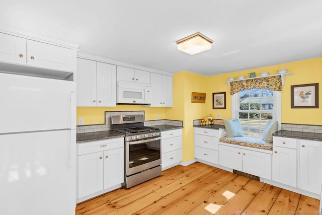 kitchen featuring white appliances, white cabinets, and light wood-style floors