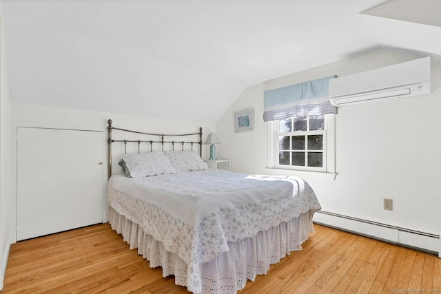 bedroom with a baseboard heating unit, lofted ceiling, wood finished floors, and a wall mounted AC