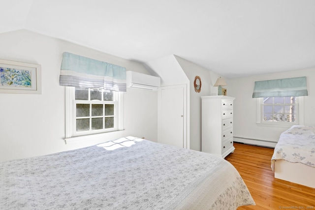 bedroom featuring a wall mounted AC, a baseboard heating unit, wood finished floors, a closet, and lofted ceiling