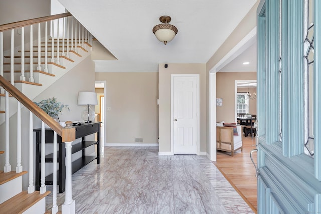 entrance foyer with visible vents, stairs, and baseboards