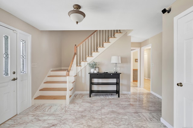 entryway featuring baseboards and stairs