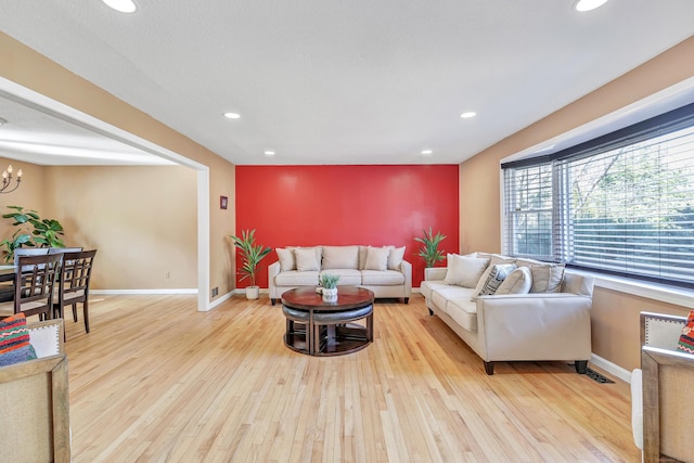 living room with a chandelier, recessed lighting, light wood-style flooring, and baseboards