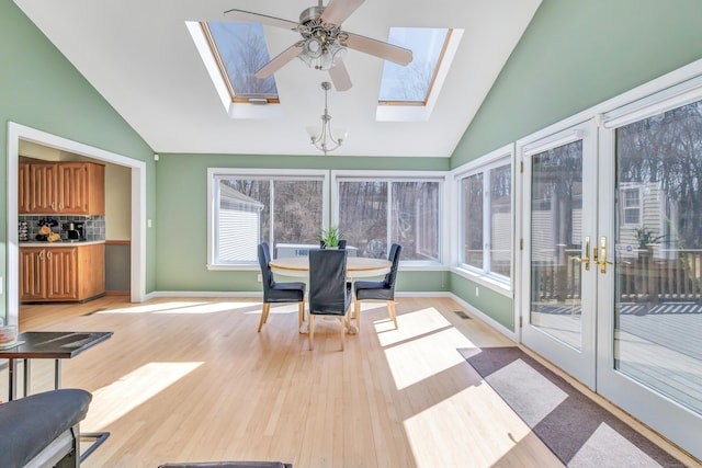 sunroom with lofted ceiling with skylight and a ceiling fan