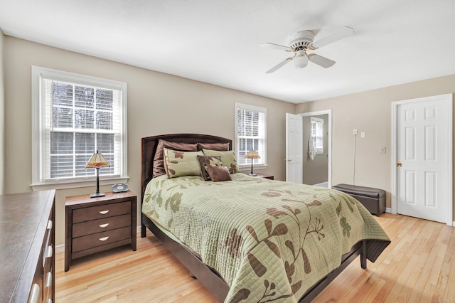 bedroom with light wood-style flooring, baseboards, and a ceiling fan